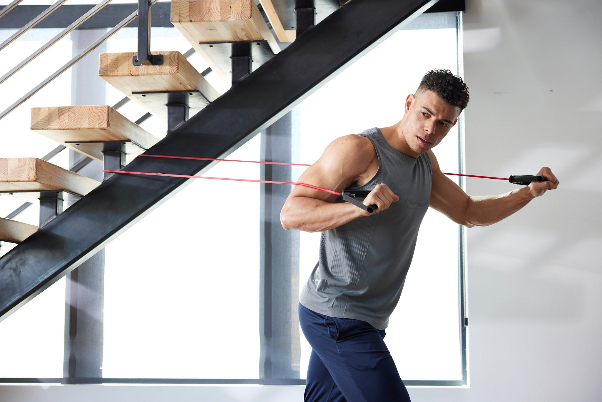 3 people work out with resistance tubes at gym